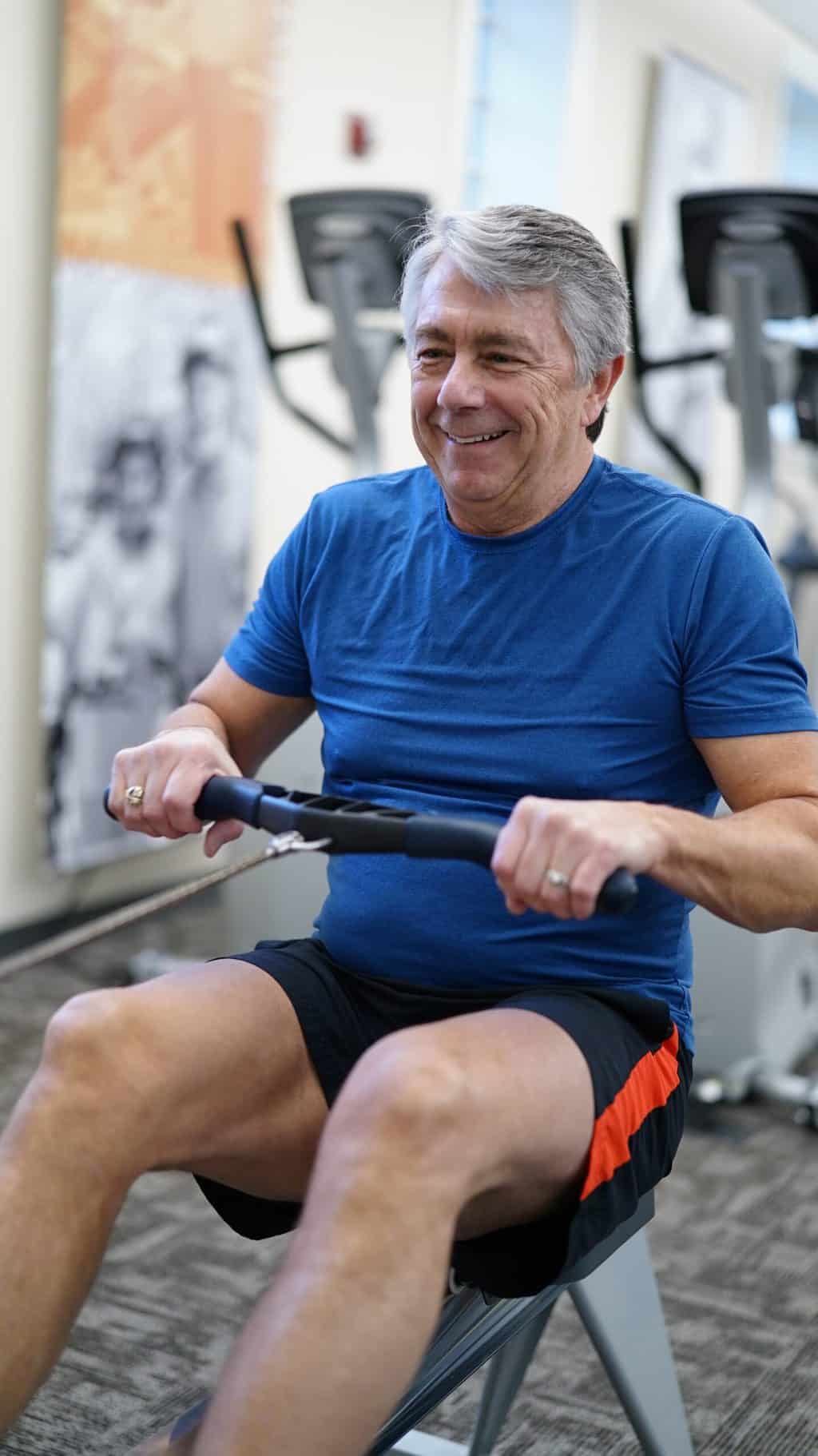 An senior man using a rowing machine