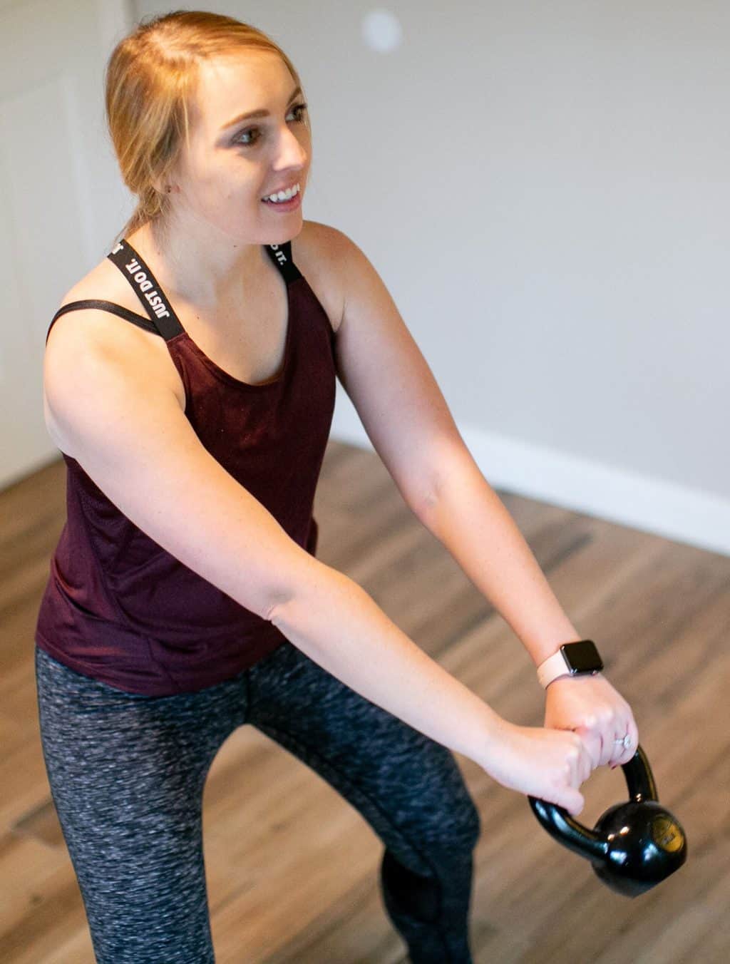 Woman trying to swing a kettlebell with both hands