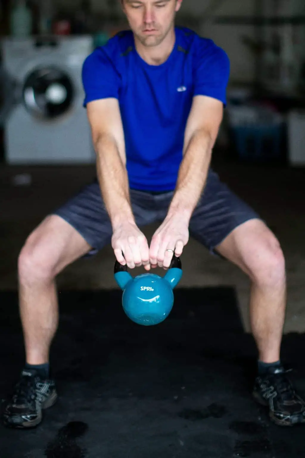 Man swinging a kettlebell with both hands