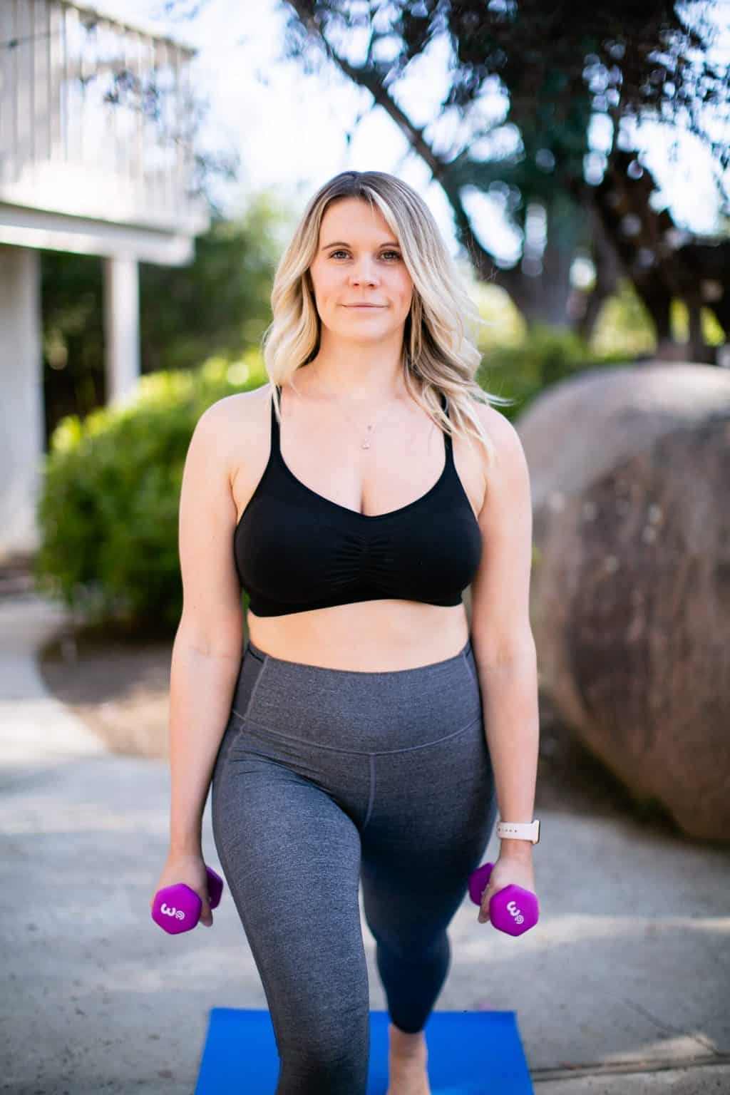 Woman doing dumbbell exercises on a mat