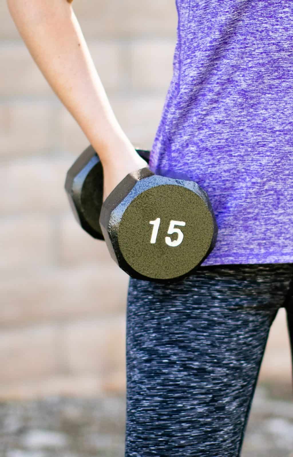 Woman holding a 15kg dumbbell