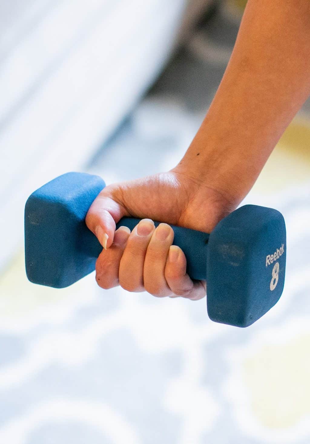 Woman using an 8kg dumbbell