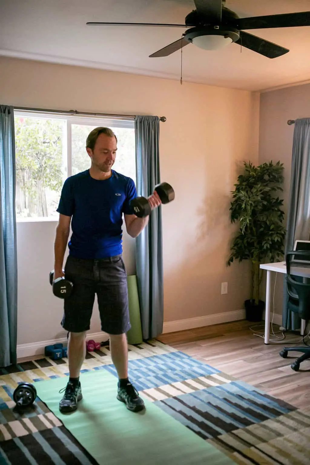 Man doing dumbbell exercises in his room