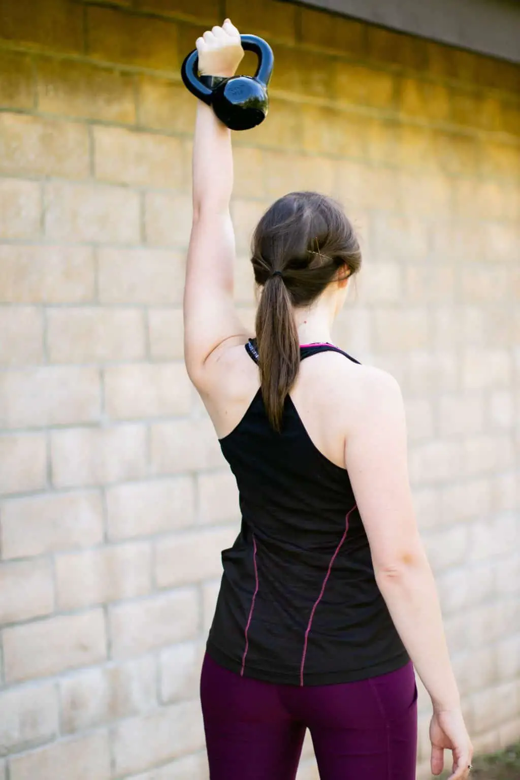Woman lifting a kettlebell with only one hand